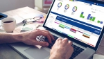 Cropped hand of graphic designer using laptop